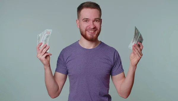 Pyšný arogantní bohatý šťastný muž držící peníze v dolarech bankovky, usmívající se, dívající se do kamery — Stock fotografie