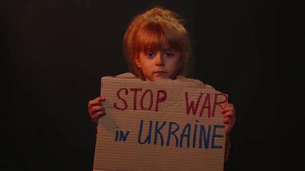 KYIV, UKRAINE - Feb 24, 2022: Hajléktalan lány gyerek bemutató karton masszázs Kezek le Ukrajna, nincs háború — Stock Fotó