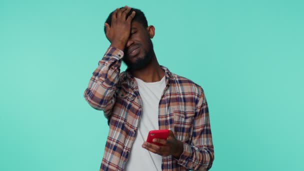 Hombre afroamericano utilizar la navegación del teléfono móvil, pierde, resultados repentinos de la lotería, mala fortuna, pérdida — Vídeos de Stock