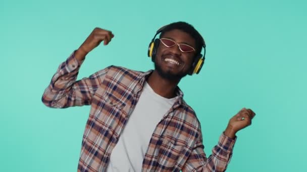 Cheerful attractive man listening music via headphones and dancing disco fooling around having fun — Stock Video