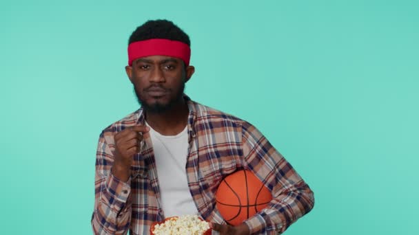 Skjeggete, afroamerikanske basketballfan som holder ball og danser alene. – stockvideo