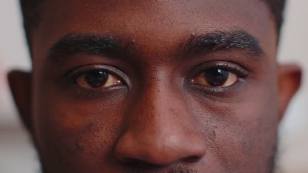 Güzelliğin makro portresi. Genç Afrikalı Amerikalı erkeklerin gözleri. Gülümseyen manken kameraya bakıyor. — Stok video