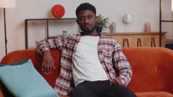 Portrait de heureux un beau garçon adolescent étudiant souriant, regardant la caméra à la maison sur le canapé — Video