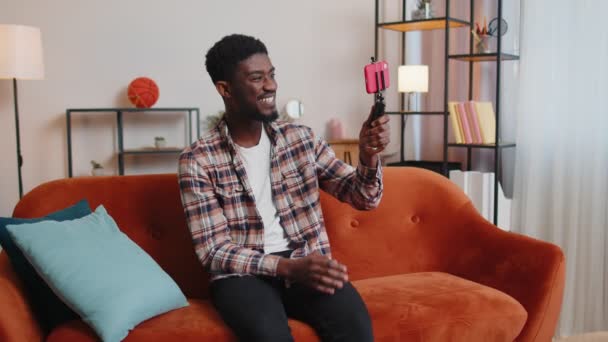 Мужчина блоггер влиятельный делает селфи на смартфоне, делает виртуальное видео в социальных сетях дома — стоковое видео