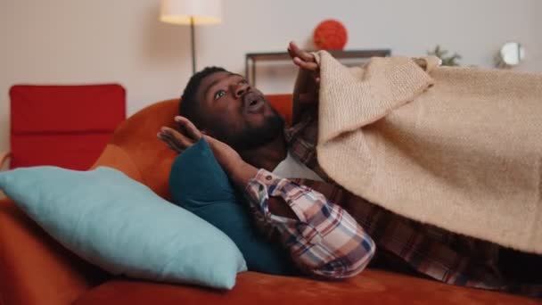 Terrified scared african american young man wakes up from stress nightmare in bedroom at home sofa — Stock Video