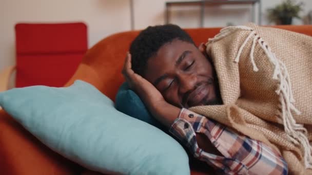Afroamerikansk ung man sover tyst i sovrummet hemma, ler, ligger på bekväm säng — Stockvideo