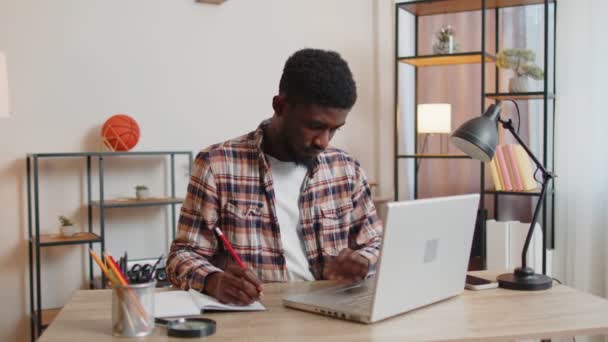 Genç adam dizüstü bilgisayar kullanıyor. Masada oturuyor, internetten alışveriş yapıyor. — Stok video