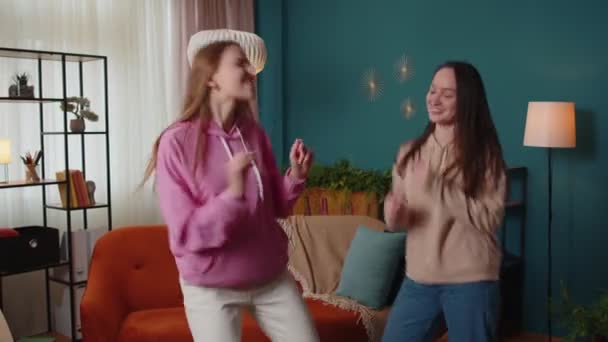 Felice due ragazze adolescenti fratelli o blogger coppia ballare a casa divertirsi godendo di danza alla moda — Video Stock