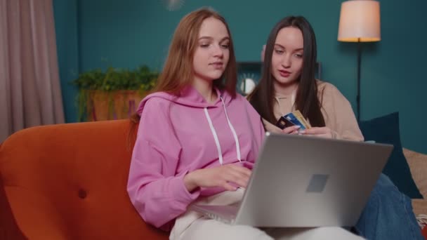 Glada tjejer vänner med kreditkort och bärbar dator samtidigt överföra pengar, inköp hemma — Stockvideo
