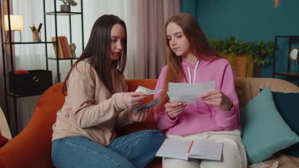 Lány testvérek ellenőrzése háztartási kifizetések, számítás számlák, úgy érzi, pánik csőd probléma — Stock videók