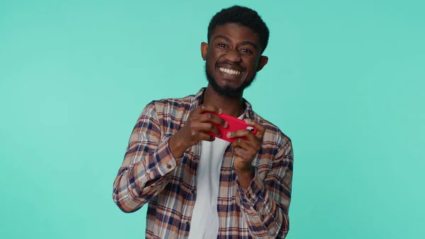 Ανησυχεί αστείο εθισμένος Αφροαμερικανός που παίζει drive αγωνιστικά βιντεοπαιχνίδια στο κινητό τηλέφωνο — Φωτογραφία Αρχείου