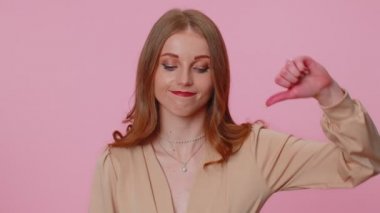 Bej bluzlu üzgün bir kız. Başparmağıyla işaret veriyor. Onaylamıyor.