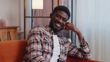 Mutlu, sakin, Afro-Amerikan sakallı, gülümseyen, başka tarafa bakan, dinlenen, tatmin olmuş genç adam.