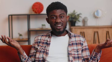 Kafası karışmış bir adam öfkeli bir ifadeyle el kaldırıyor ve neden evde başarısız olduğunu soruyor.