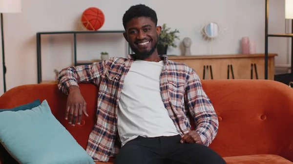 Mutlu bir genç çocuğun portresi. Kanepede kameraya bakıp gülümseyen güzel bir genç.