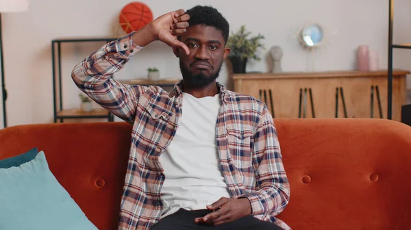 Başparmak işareti gösteren genç adam memnuniyetsizlik, hoşnutsuzluk ve hoşnutsuzluğu ifade ediyor.