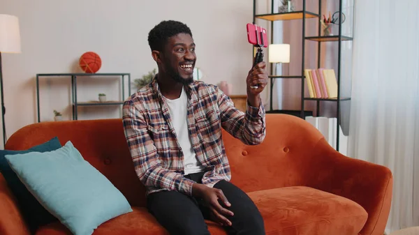 Blogcu etkileyicisi akıllı telefondan selfie çekiyor, evde sanal sosyal medya videosu yapıyor.