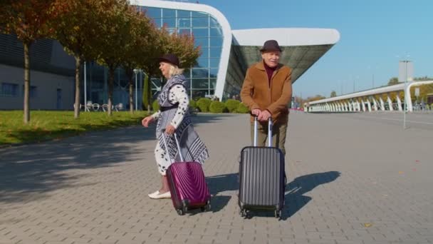 Дедушка с чемоданами идет в зал аэропорта, празднует танцы — стоковое видео