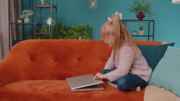 Neşeli liseli kız evde tek başına bilgisayar kullanarak online eğitim dersleri alıyor. — Stok video