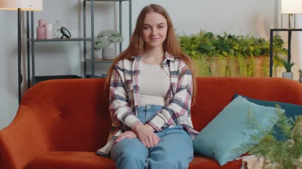 Πορτρέτο της ευτυχίας ένα όμορφο κορίτσι έφηβος φοιτητής χαμογελώντας, κοιτάζοντας κάμερα στο σπίτι στον καναπέ — Αρχείο Βίντεο