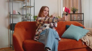 Blog yazarı etkileyicisi akıllı telefondan selfie çekiyor, evde sanal sosyal medya videosu çekiyor