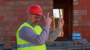 Mühendis mimar onaylayıcı bir şekilde kameraya bakıyor. Onaylıyor, ev almayı öneriyor.