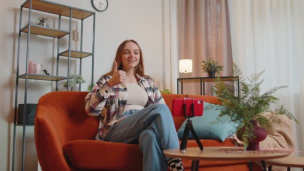 여자 블로거가 스마트폰으로 셀카를 찍고 가상 소셜 미디어 비디오를 집에서 만들고 있습니다. — 비디오