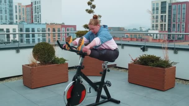 Femme sportive caucasienne saine faisant de l'exercice d'étirement sur un vélo de machine à vélo stationnaire — Video