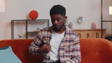 Mutlu Afro-Amerikalı genç bir öğrencinin portresi gülümseyen, evdeki kanepede kameraya bakan