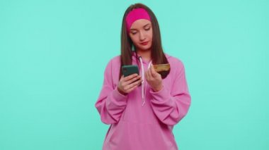 Cep telefonu ve plastik kredi kartı kullanan bir kız 
