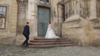 Güzel yeni evliler, beyaz gelin ve damat kalenin yanında buketli, ilk tanışma çifti.