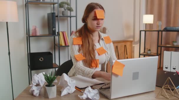 Εξαντλημένη γυναίκα ελεύθερη επαγγελματίας με επικολλημένα αυτοκόλλητα χρησιμοποιώντας φορητό υπολογιστή που έχει πρόβλημα συγκέντρωσης στο γραφείο — Αρχείο Βίντεο
