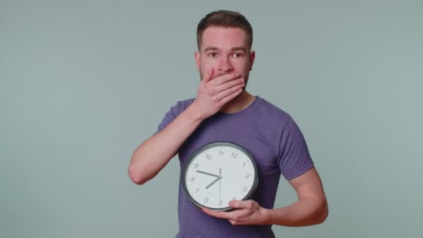 Confused man with anxiety checking time on clock, running late to work, being in delay, deadline — Stock Video