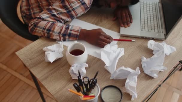 Κουρασμένος άνθρωπος στο γραφείο στο σπίτι κοιμάται στο τραπέζι με φορητό υπολογιστή, τσαλακωμένα φύλλα χαρτιού — Αρχείο Βίντεο