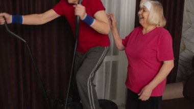 Sağlıklı yaşlı büyükbaba modellik yapıyor. Yörünge sporu yapıyor. Evdeki odada.