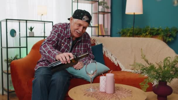 Uśmiechnięty starszy dziadek człowiek pije czerwone wino szklanki świętując urodziny rocznica wygrana loterii — Wideo stockowe