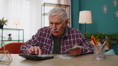 Mutlu büyükbaba nakit para hesaplıyor. Masraflar hesaplanıyor. Mali bütçe.