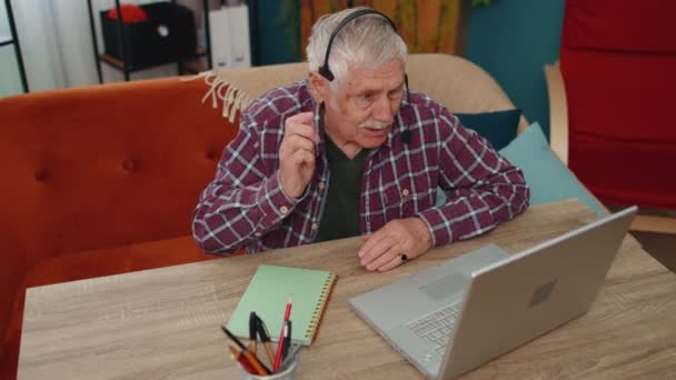 Homme âgé casque freelance porter faire appel vidéo parler, l'enseignement à l'ordinateur portable au bureau à la maison — Video