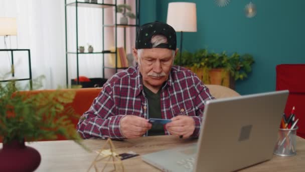 Senior Opa Mann tippt Kreditkarten-Informationen auf Laptop, macht Internet-Online-Shopping