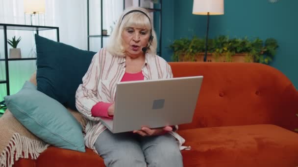 Senior Frau freiberuflich Kopfhörer machen Videoanrufe sprechen, Unterricht am Laptop zu Hause im Büro — Stockvideo