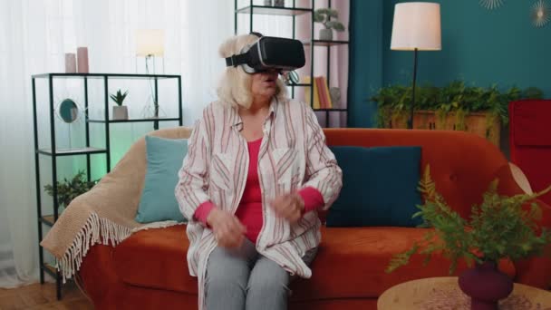 Senior kvinna som använder VR app headset hjälm för att spela simulering 3D 360 videospel online — Stockvideo