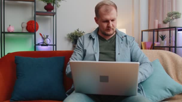 Vuxen man på hemmakontoret använda laptop pc skriva bläddra säga wow ja fick reda på stor seger fira — Stockvideo