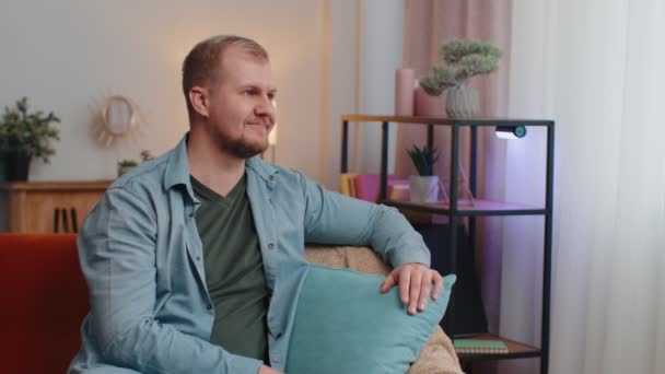 Feliz calma adulto caucásico barbudo hombre sonriendo mirando hacia otro lado soñando descansando, sentirse satisfecho en casa — Vídeo de stock