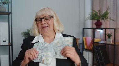 İş kadını muhasebeci iş başarısını kutluyor. Para yığını ile dans ediyor.