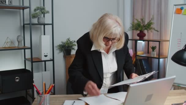 Senior Business Frau prüft Diagramme, analysiert, verwaltet Finanzdokumente Bericht im Home Office — Stockvideo