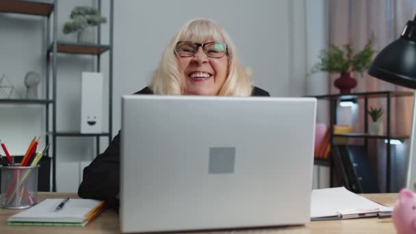 Senior volwassen oudere zakenvrouw verbergen achter laptop computer, het maken van grappig gezicht, rotzooien rond — Stockvideo