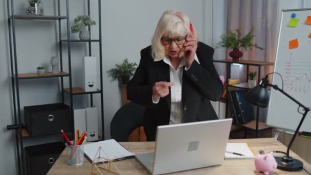 Zły starszy biznes kobieta podejmowania rozmowy telefonicznej w biurze pracy zirytowany szef mówi mobilny kłótnia — Wideo stockowe