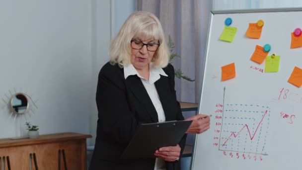 Senior mujer de negocios entrenador líder conferencia orador explicar la estrategia del proyecto en pizarra de oficina — Vídeos de Stock