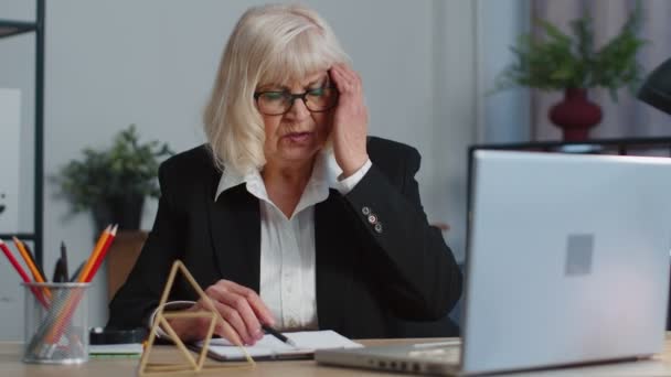 Tired senior business woman office freelancer teacher using laptop suffering from migaine headache — ストック動画