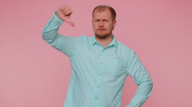 Sıradan gömlekli üzgün bir adam. Başparmak işareti işareti, onaylamama, memnuniyetsizlik gösteriyor.